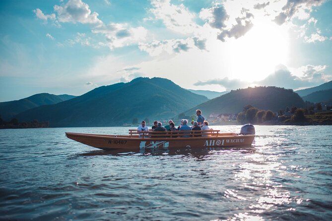 Wine tasting on traditional wooden boats in Wachau Valley - Dürnstein from the water: castle, abbey, and the burgruine